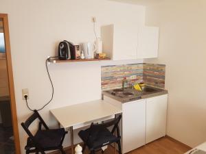 a small kitchen with a table and two chairs at Ferienwohnung Kramer in Kippenheim