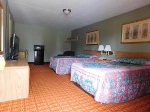 Habitación de hotel con 2 camas y TV de pantalla plana. en Westgate Motel en Youngstown