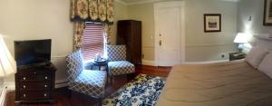 ein Wohnzimmer mit einem Bett und einem TV in der Unterkunft Inn on Bellevue in Newport