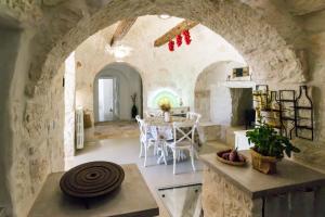 奧斯圖尼的住宿－Trullo Picchiagiuda，大房间设有桌子和石墙
