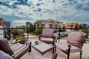 a balcony with two chairs and a table on a balcony at Boutique Vila White Duchess in Mamaia Nord