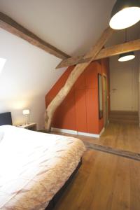 a bedroom with a large bed and wooden floors at B&B Crijbohoeve stallen en weidegang voor paarden mogelijk in Zutendaal