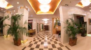 a lobby with a checkered floor and two plants at Golden Coast in Baku
