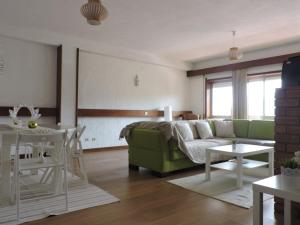 a living room with a green couch and a table at T3 em Sever do Vouga in Sever do Vouga