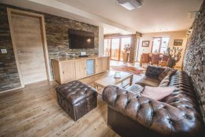 a living room with a leather couch and a television at Downtown Suite Alpi in Garmisch-Partenkirchen
