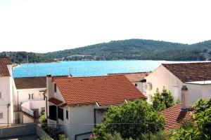 a group of buildings with a lake in the background at Apartments Villa Russo in Tisno