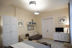 a bedroom with a bed and a couch and a desk at Zora Apartman in Eger
