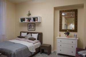 a bedroom with a bed and a mirror and a dresser at Zora Apartman in Eger