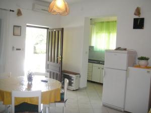 a kitchen with a table and a refrigerator at Apartments Ivan Orlic in Vinišće