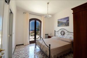 a bedroom with a bed and a balcony at Il Paradiso Di Hyele in Ascea