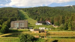 a building in the middle of a hill with a lake at Apartment Gondola in Maribor