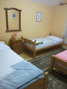 a small bedroom with two beds and a mirror at Bravo Guest House in Bihać