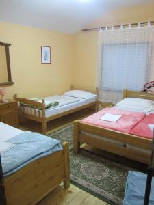 a room with three beds and a window at Bravo Guest House in Bihać