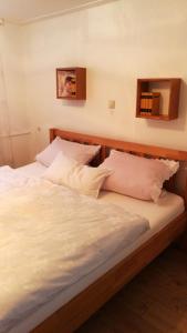 a bed with white sheets and pillows in a room at Ferienwohnung Adelsberg in Alpirsbach