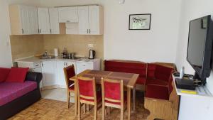 a kitchen and dining room with a table and a couch at Central Apartment in Nikšić
