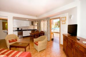 a living room and kitchen with a couch and a table at Apartamentos Ecuador Park in Torremolinos