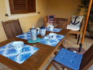 a wooden table with blue and white dishes on it at La dimora del capitano in San Vito lo Capo