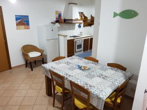 a kitchen with a table and a table and chairs at La dimora del capitano in San Vito lo Capo