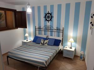 a bedroom with a bed with blue and white stripes at La dimora del capitano in San Vito lo Capo