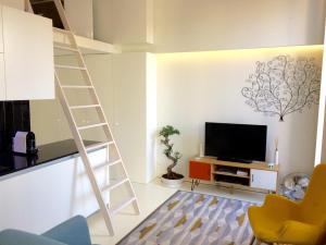 a living room with a ladder and a television at PortoWhite city lofts in Porto