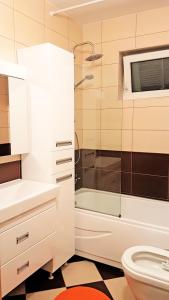 uma casa de banho com um chuveiro, um lavatório e um WC. em Apartment 13 em Pristina