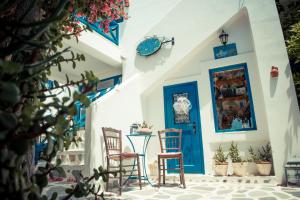 Habitación con 2 sillas y puerta azul en Dora's Studios & Apartments, en Megas Gialos - Nites