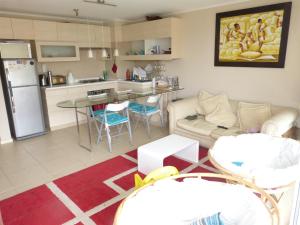 a kitchen and living room with a couch and a table at Laguna vista 903 in Algarrobo +6 photos