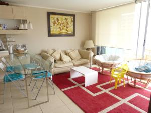 a living room with a couch and a glass table at Laguna vista 903 in Algarrobo