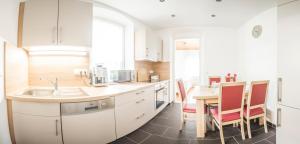 a kitchen with a sink and a table with chairs at Ferienwohnung Alpi in Garmisch-Partenkirchen