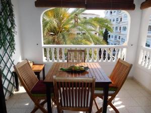 a wooden table and chairs on a balcony at Las Dunas Apartment in Albir