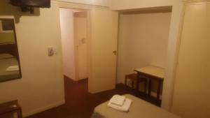 Habitación pequeña con cama y espejo. en Hotel Compostela en Mar del Plata