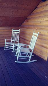 2 chaises assises sur une terrasse couverte d'une cabine dans l'établissement Wonder Inn Outback, à Panguitch