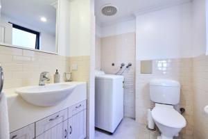 Baño blanco con lavabo y aseo en Fremantle Townhouse Unit 6 en Fremantle