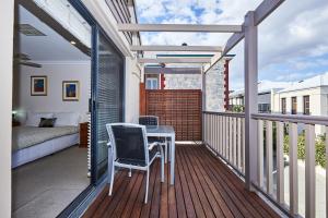Un balcón con una mesa y una cama. en Fremantle Townhouse Unit 6 en Fremantle