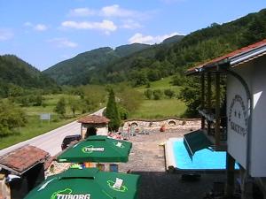 ein Resort mit einem Pool und einem grünen Sonnenschirm in der Unterkunft Rooms for Guests Bakhus in Šipkovo