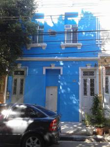 un edificio azul con un coche aparcado delante de él en Hostel Cidade Nova, en Río de Janeiro