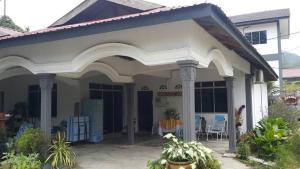 a house with a porch with a table and chairs at Hana Guesthouse in Kuala Tahan