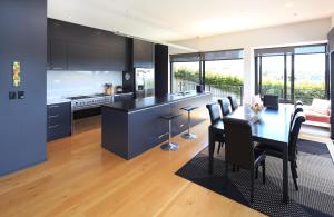 a kitchen and dining room with a table and chairs at Blackwood Retreat in Oneroa
