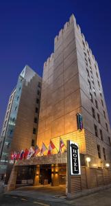 un gran edificio con un cartel delante en Capace Hotel Gangnam en Seúl