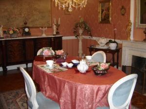 comedor con mesa roja con sillas y chimenea en Chambres d'Hôtes Ty Mezad, en Séné