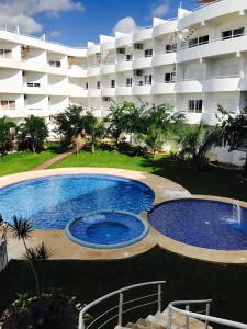 a swimming pool in front of a large building at Luxury Suites at Suites Cozumel in Cozumel