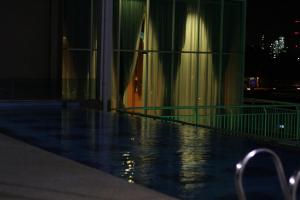 una piscina por la noche con un edificio en Paradise Spa Hotel, en Port Dickson