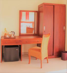 Doremi Ubud Guesthouse في أوبود: مكتب خشبي مع مرآة وكرسي