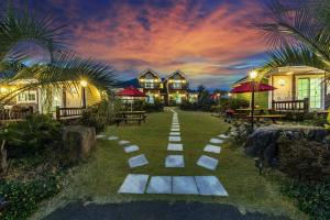 a pathway in the yard of a resort at night at Jubilee Chalet in Seogwipo