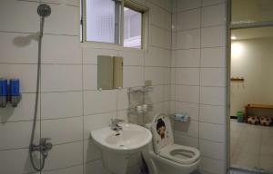 a bathroom with a sink and a toilet at Wooden Man Homestay in Taitung City