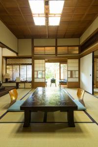 Großes Zimmer mit einem Tisch und Stühlen in der Unterkunft Ryokan Seifuso in Ōmuta