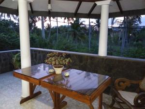 a wooden table sitting on a porch with a table at The Rock House in Katunayaka