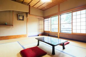 a room with a table in a room with windows at 高野山 宿坊 増福院 -Koyasan Shukubo Zofukuin- in Koyasan