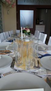 a long table with glasses and plates on it at Villa Nobis in Łeba