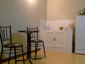 a kitchen with three chairs and a table and a refrigerator at Condo Muang Thong in Nonthaburi